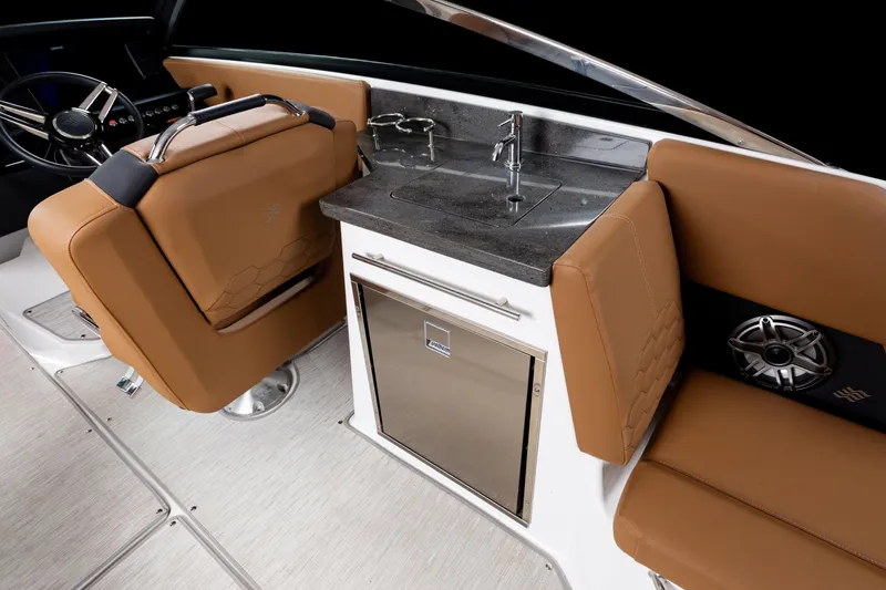 Slide: The Image of 2026 Four Winns H9 OB boat interior with brown seating, sink, and stainless steel accents. - 21