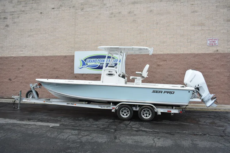 The Image of 2025 Sea Pro 250 Bay boat on trailer, parked outside dealership. - 0
