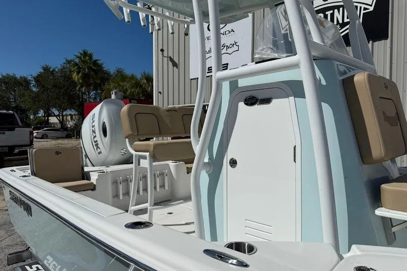Slide: The Image of 2026 Sea Pro 210 Bay boat with seating and Suzuki engine, parked outdoors. - 6
