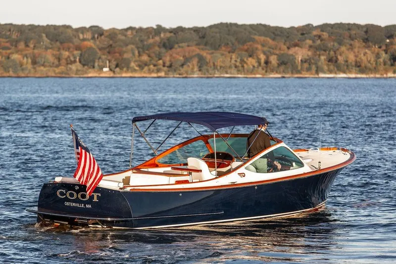 Slide: The Image of 2005 Hinckley Talaria 29R boat on water, American flag, scenic background. - 8