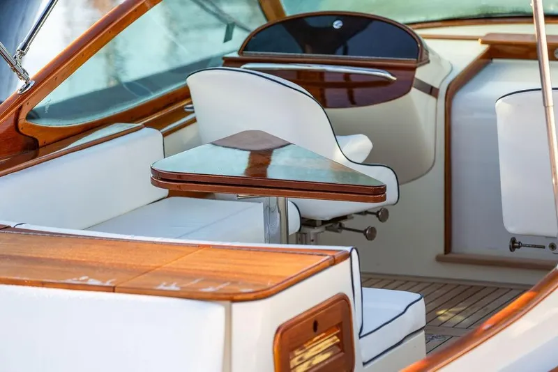 Slide: The Image of Interior of 2005 Hinckley Talaria 29R yacht with elegant wood and white seating. - 17