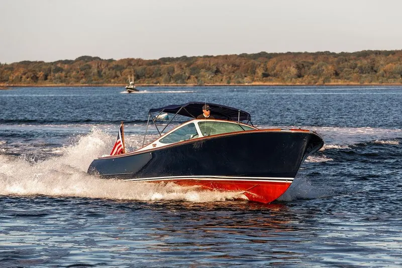 Slide: The Image of 2005 Hinckley Talaria 29R cruising on a scenic lake with forested shoreline. - 4