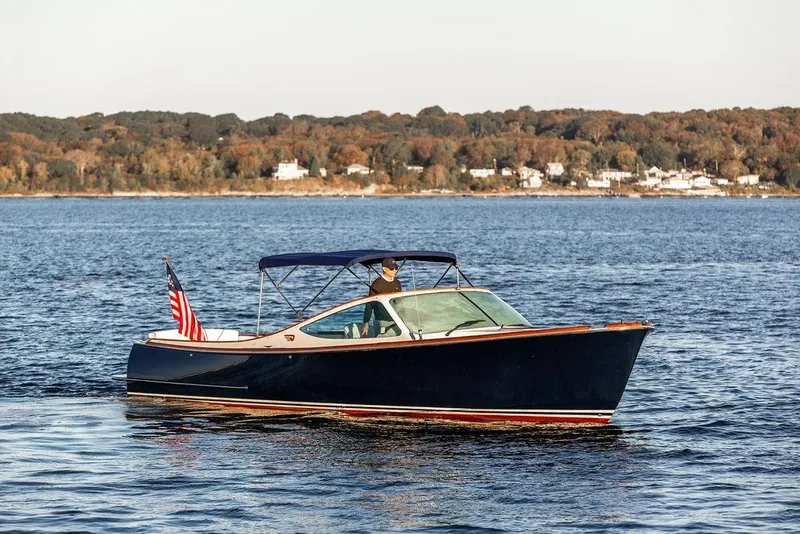 Slide: The Image of 2005 Hinckley Talaria 29R cruising on a serene lake with autumn foliage in the background. - 5