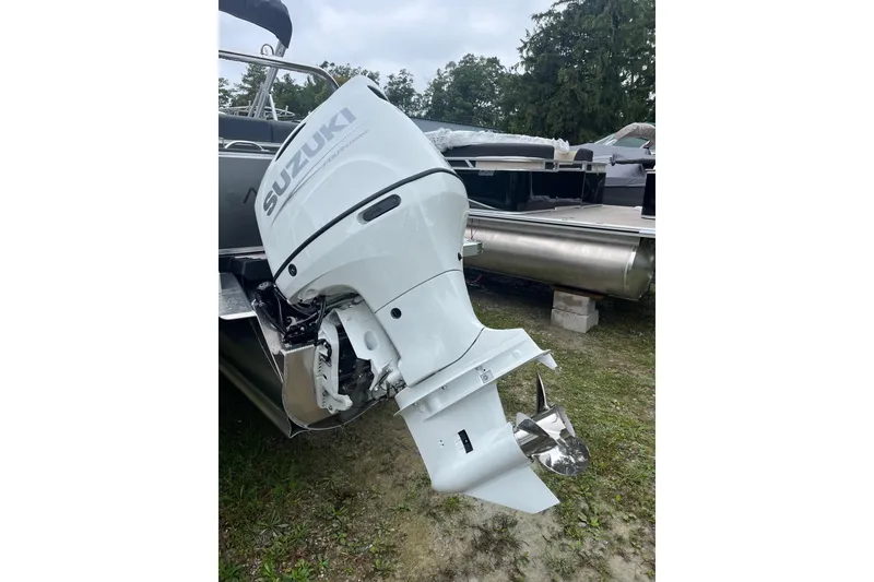 Slide: The Image of 2026 Avalon 25 LSZ ELITE with Suzuki outboard motor, parked on grass. - 10