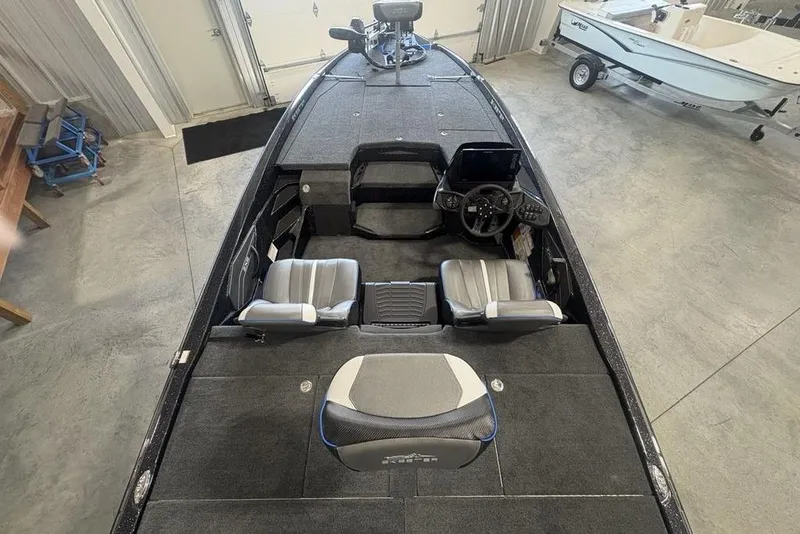 Slide: The Image of 2026 Skeeter ZXE20 boat interior with dual seats and steering console in a garage setting. - 25