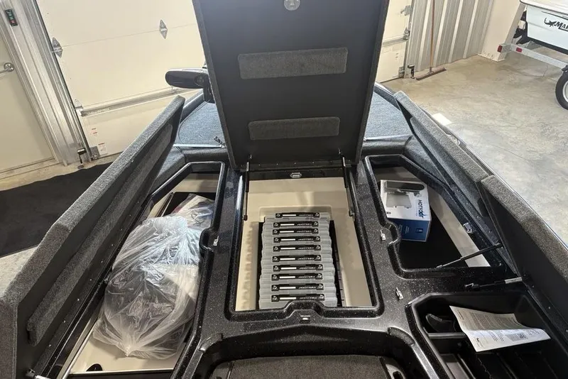 Slide: The Image of 2026 Skeeter ZXE20 boat storage compartments open in a garage setting. - 4
