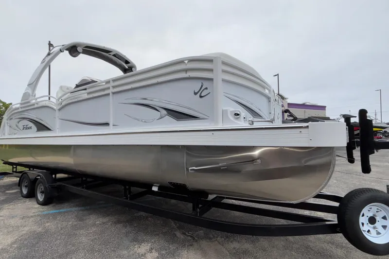 Slide: The Image of 2026 JC NEPTOON 27TT SPORT pontoon boat on trailer, sleek design, parked outdoors. - 2