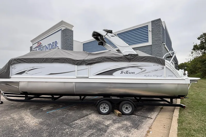 Slide: The Image of 2026 JC Neptoon 27TT Sport boat on trailer, covered, near a building. - 27