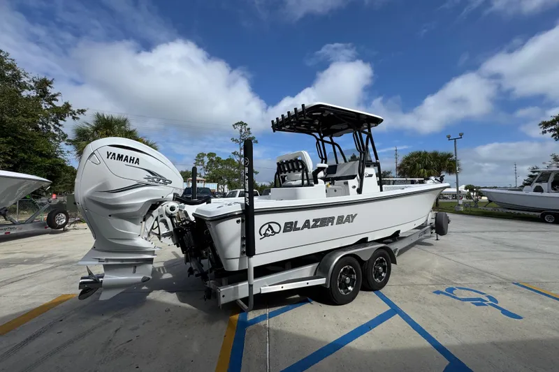 Slide: The Image of 2021 Blazer Bay 2700 Hybrid boat with Yamaha engine on trailer, parked outdoors. - 10
