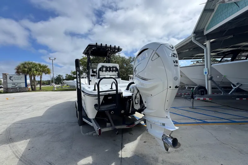 Slide: The Image of 2021 Blazer Bay 2700 Hybrid boat with Yamaha V8 engine in a marina setting. - 13