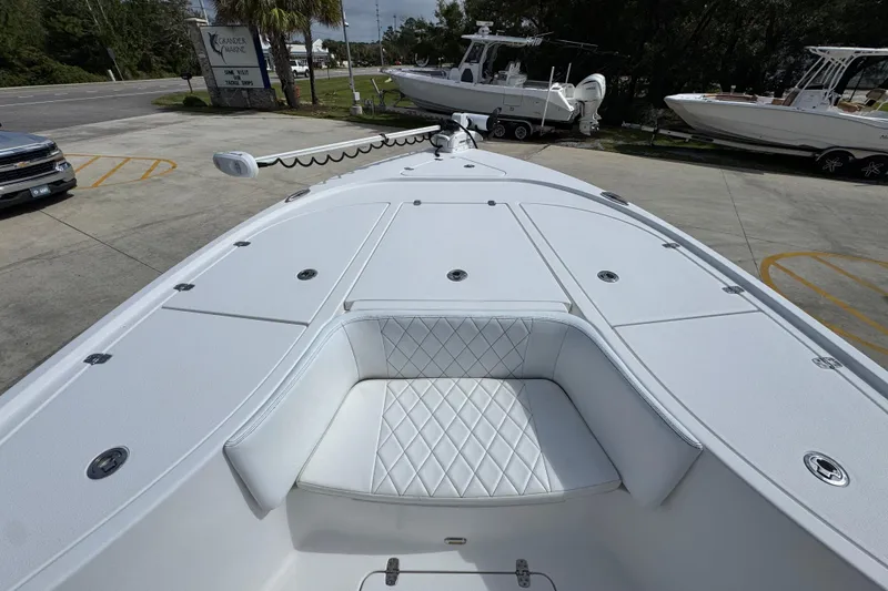 Slide: The Image of 2021 Blazer Bay 2700 Hybrid boat with white seating and deck, parked outdoors. - 16