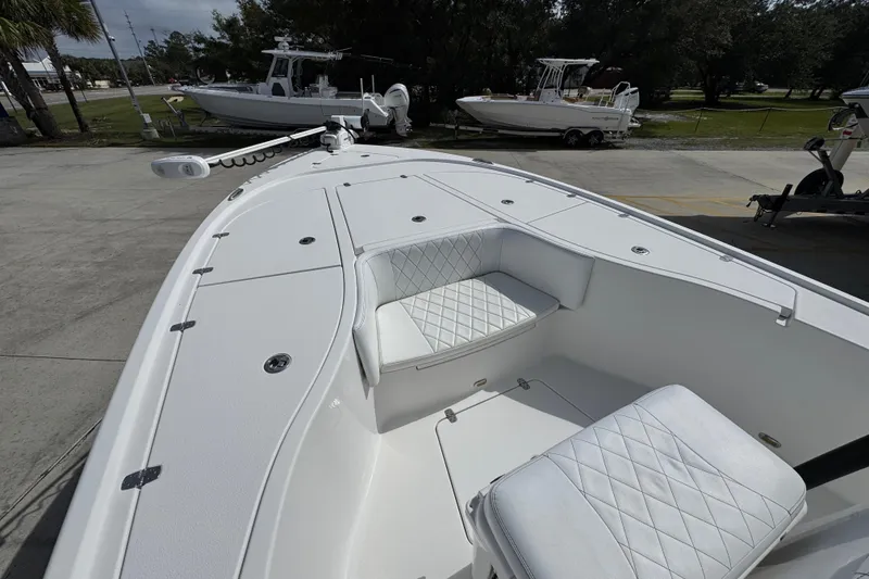 Slide: The Image of 2021 Blazer Bay 2700 Hybrid boat with white seating and deck, parked outdoors. - 17