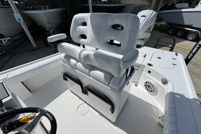 Slide: The Image of 2021 Blazer Bay 2700 Hybrid boat interior with white seating and steering wheel. - 23
