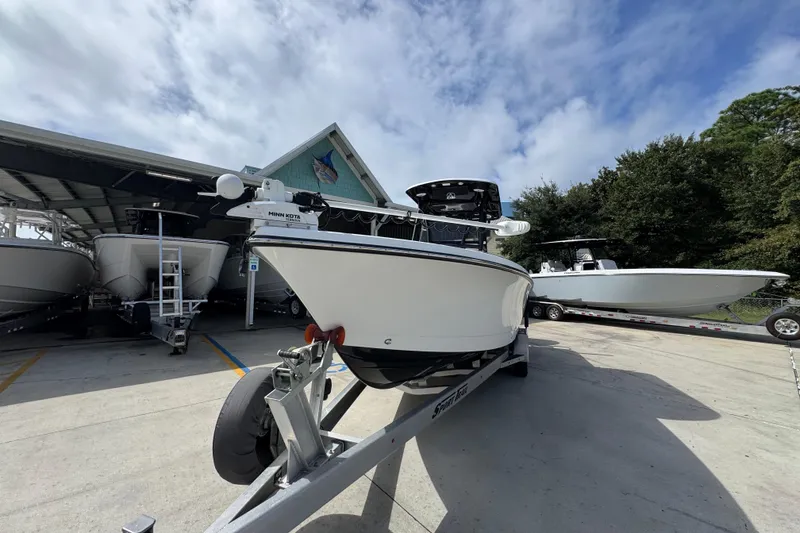 Slide: The Image of 2021 Blazer Bay 2700 Hybrid boat on trailer, parked outdoors under cloudy sky. - 4