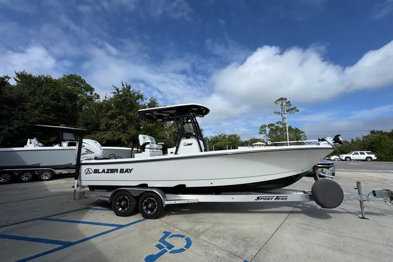 Slide: The Image of 2021 Blazer Bay 2700 Hybrid boat on trailer under blue sky. - 8