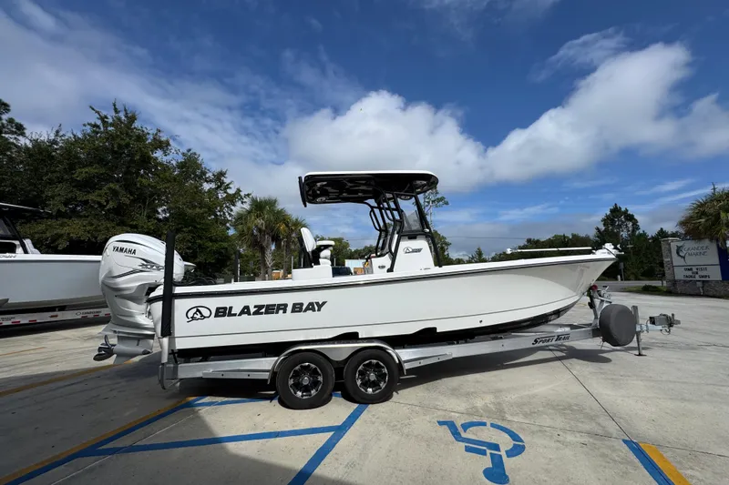 Slide: The Image of 2021 Blazer Bay 2700 Hybrid boat on trailer, parked outdoors under blue sky. - 9