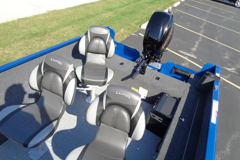 Slide: The Image of 2026 Lund 1650 Rebel Tiller boat interior with four seats and motor. - 5