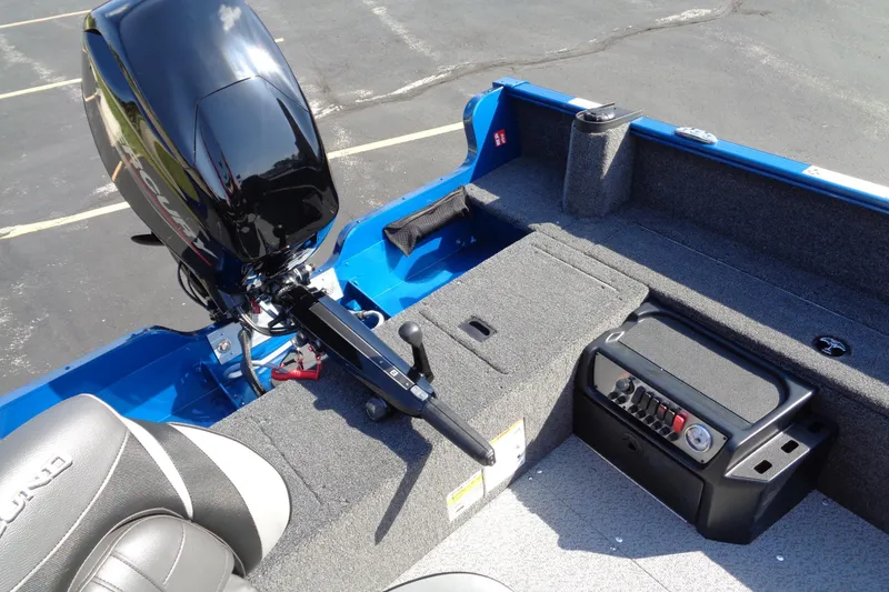 Slide: The Image of 2026 Lund 1650 Rebel Tiller boat interior with motor and seating, featuring blue and gray design. - 6