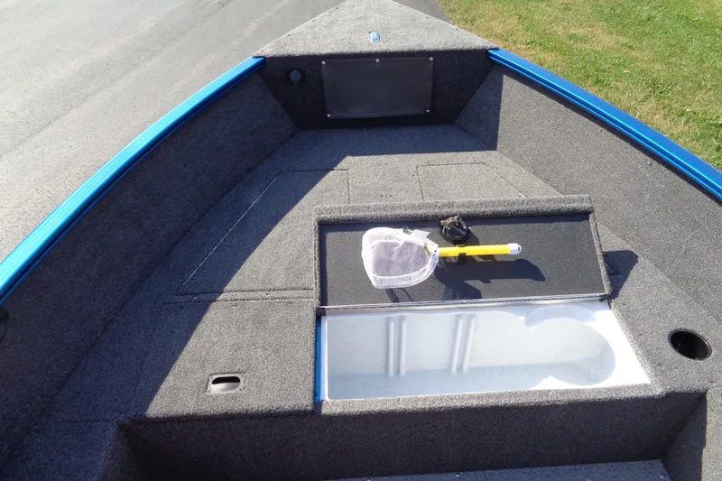 Slide: The Image of 2026 Lund 1650 Rebel Tiller boat interior with storage compartments and fishing net. - 8