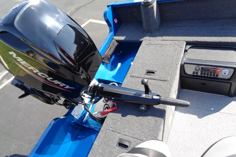 Slide: The Image of 2026 Lund 1650 Rebel Tiller boat with Mercury engine, featuring a sleek blue interior. - 9