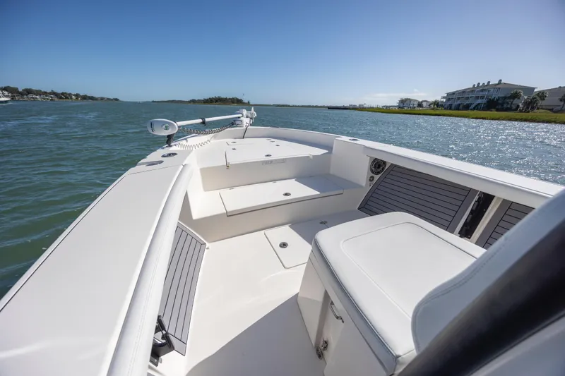 Slide: The Image of 2023 Pathfinder 2700 Open boat on calm water, showcasing spacious deck and seating. - 10