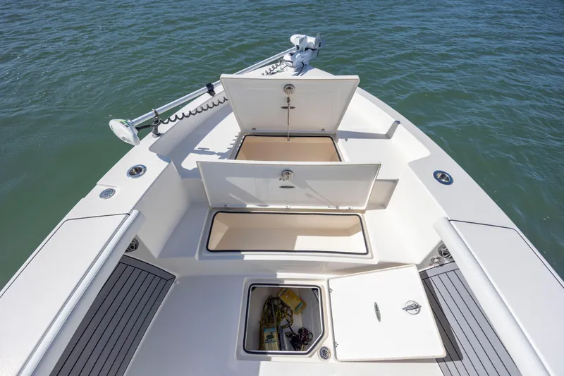Slide: The Image of 2023 Pathfinder 2700 Open boat with open storage compartments on calm water. - 12