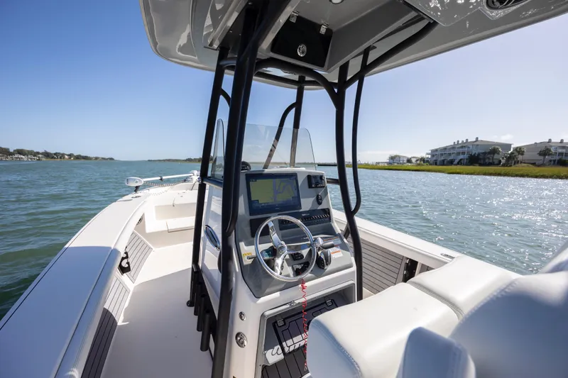 Slide: The Image of 2023 Pathfinder 2700 Open boat interior with steering wheel and navigation system on calm water. - 22