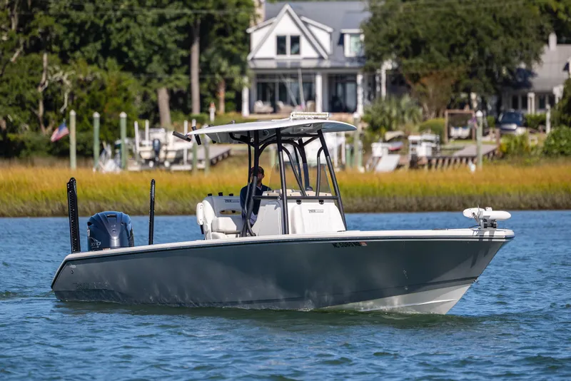 Slide: The Image of 2023 Pathfinder 2700 Open boat cruising on a scenic waterway near waterfront homes. - 3