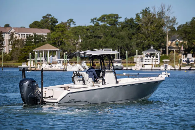 Slide: The Image of 2023 Pathfinder 2700 Open boat cruising on a scenic waterway near docks and trees. - 7