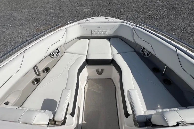 Slide: The Image of 2023 Regal LX4 boat interior with white cushioned seating and cup holders. - 10