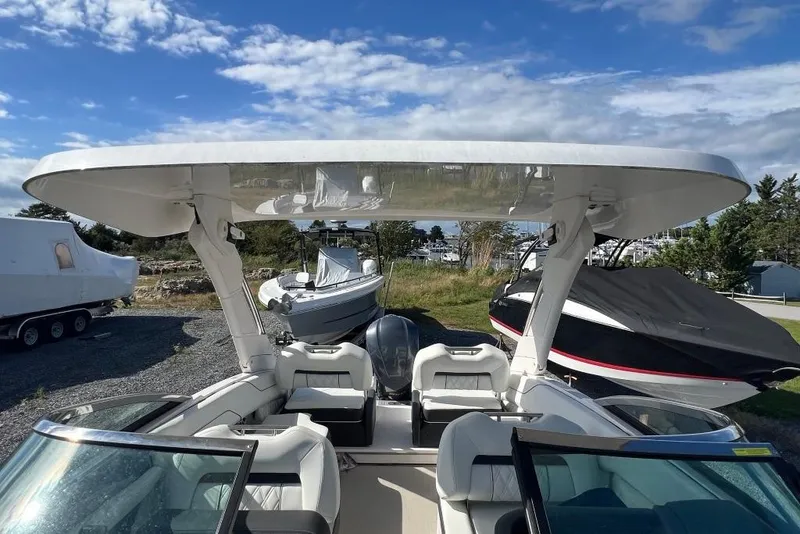 Slide: The Image of 2023 Regal LX4 boat with sleek design, parked outdoors under a clear blue sky. - 12