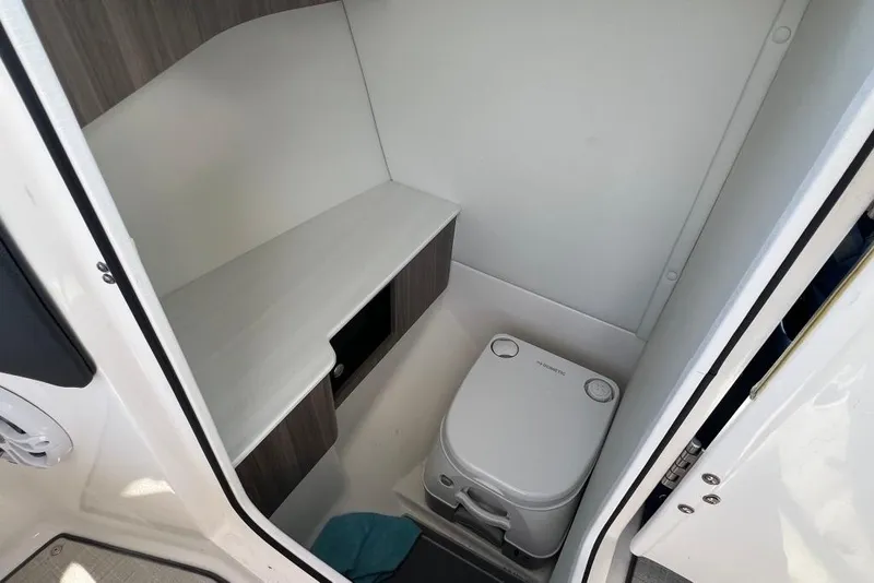 Slide: The Image of 2023 Regal LX4 boat interior with compact toilet and storage area. - 9