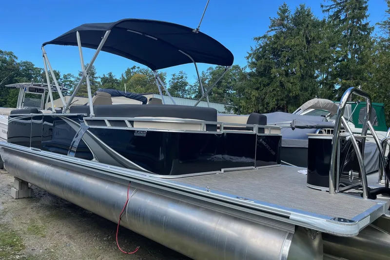 Slide: The Image of 2026 Avalon 25 LSZ Quad Lounger pontoon boat with canopy, docked outdoors. - 10