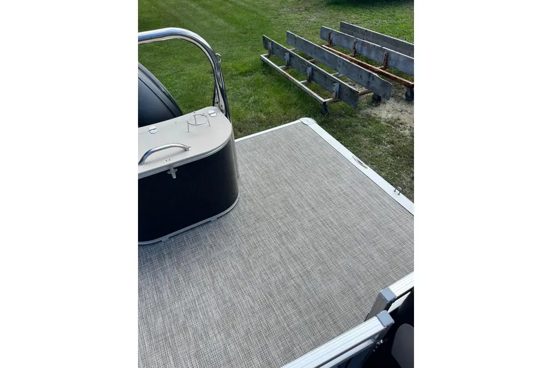 Slide: The Image of 2026 Avalon 25 LSZ Quad Lounger pontoon boat deck with railing, on grassy area. - 3
