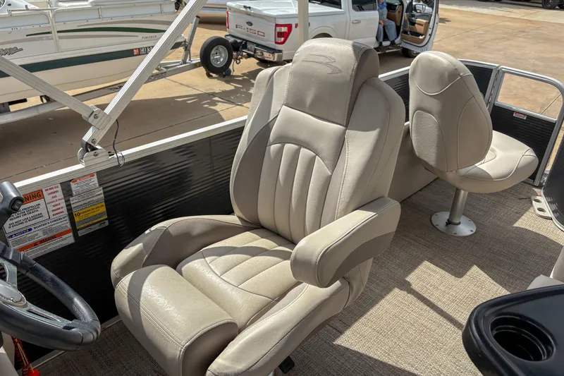 Slide: The Image of 2018 Bennington SX 20 boat interior with beige captain's chair and steering wheel. - 11