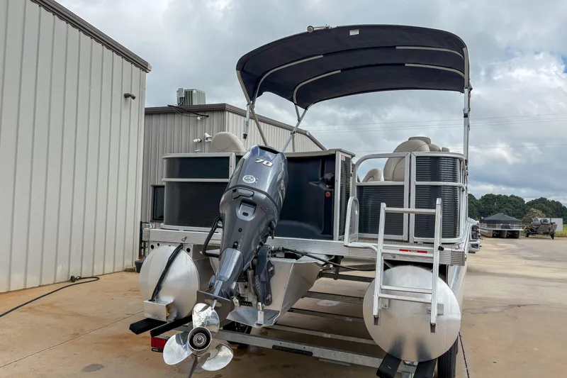 Slide: The Image of 2018 Bennington SX 20 pontoon boat with outboard motor, parked outdoors. - 4