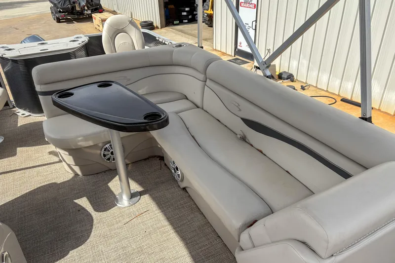 Slide: The Image of 2018 Bennington SX 20 pontoon boat interior with beige seating and black table. - 9