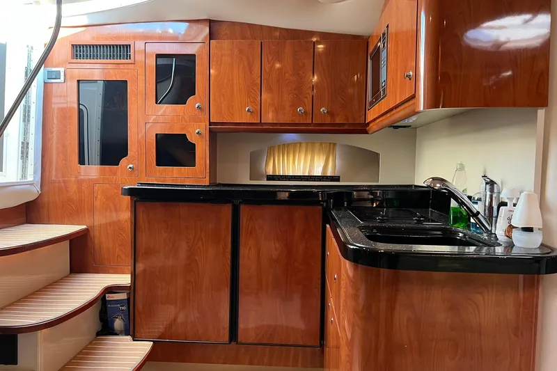 Slide: The Image of Luxurious 2008 Four Winns 378 Vista yacht interior with polished wood cabinetry and modern kitchen amenities. - 43