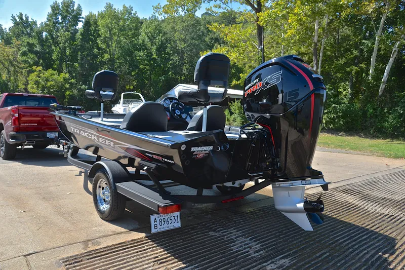 Slide: The Image of 2023 Bass Tracker PRO TEAM 190 boat on trailer, parked near a red truck. - 12