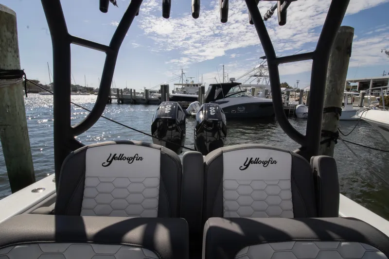Slide: The Image of 2025 Yellowfin 32 Offshore boat docked with twin engines, sunny marina view. - 11