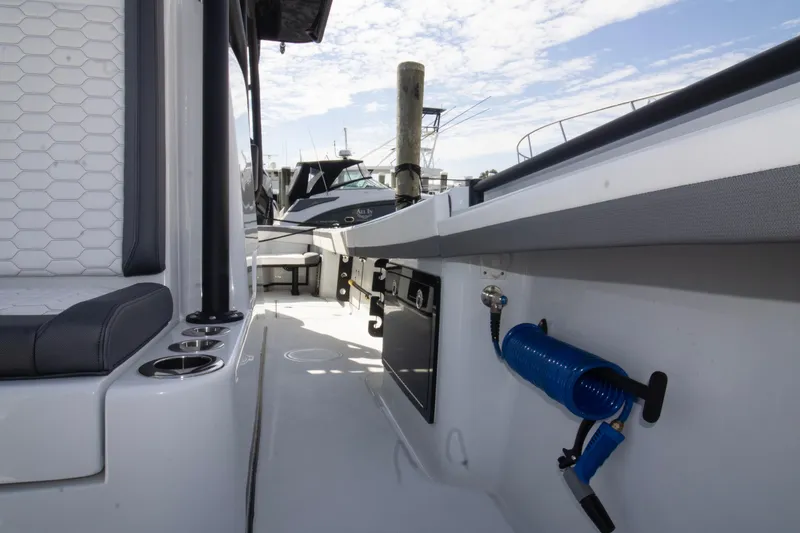 Slide: The Image of 2025 Yellowfin 32 Offshore boat interior with seating and equipment, docked under a blue sky. - 13