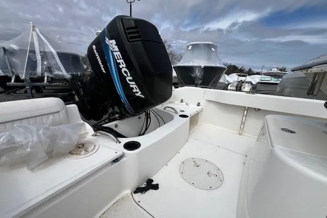 Slide: The Image of 2005 Boston Whaler 190 Nantucket boat with Mercury engine, docked under cloudy sky. - 11