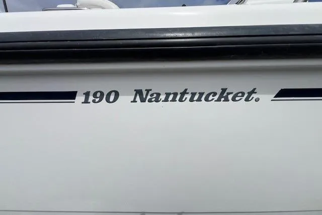 Slide: The Image of 2005 Boston Whaler 190 Nantucket boat model name on hull. - 13