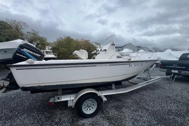 Slide: The Image of 2005 Boston Whaler 190 Nantucket boat on trailer, parked outdoors under cloudy skies. - 16