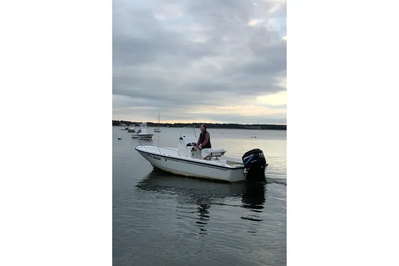 Slide: The Image of 2005 Boston Whaler 190 Nantucket boat on calm water under cloudy sky. - 18