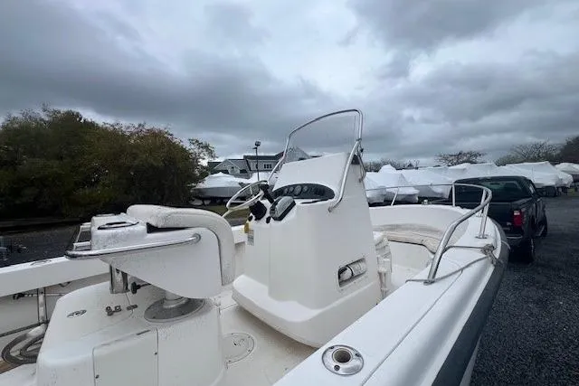 Slide: The Image of 2005 Boston Whaler 190 Nantucket boat with center console, parked outdoors under cloudy skies. - 19