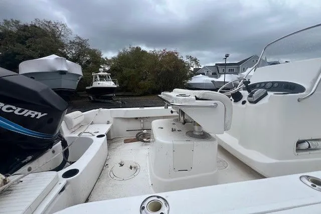 Slide: The Image of 2005 Boston Whaler 190 Nantucket boat with Mercury engine, docked under cloudy skies. - 20