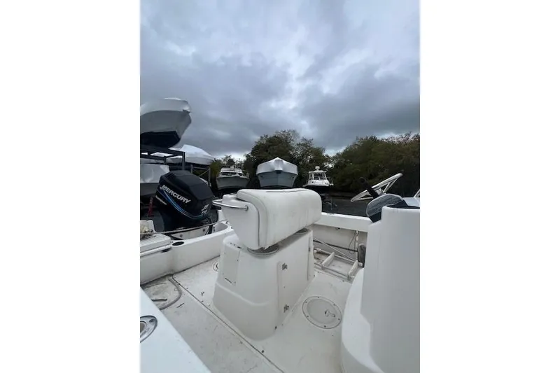 Slide: The Image of 2005 Boston Whaler 190 Nantucket boat interior with Mercury engine, under cloudy sky. - 21