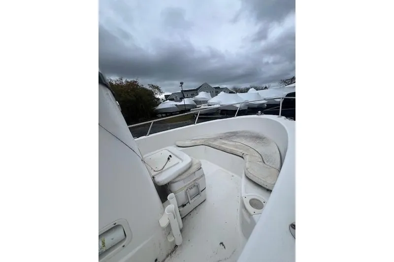 Slide: The Image of 2005 Boston Whaler 190 Nantucket boat deck under cloudy sky, with covered boats nearby. - 22
