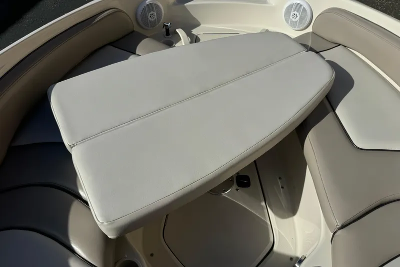Slide: The Image of 2005 Sea Ray 240 Sundeck interior with cushioned seating and table. - 18